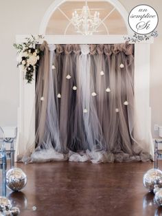 a wedding ceremony setup with silver balloons and white flowers on the floor, chandelier hanging from the ceiling