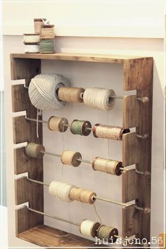 an old wooden rack holds several spools of thread