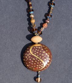 Large round brown Kazuri focal bead with a splash of gold accents.  This necklace features an assortment of Czech glass beads and Japanese pearls - in tones of brown. AMAZING! Kazuri Beads, Japanese Pearls, Rainbow Necklace, Rainbow Swirl, Jasper Necklace, Wine Bag, Gold Tone Necklace, Handmade Gold, Focal Bead