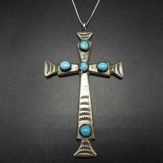 "VINTAGE NAVAJO CROSS PENDANT DESCRIPTION: This impressive pendant is casst and hand-stamped the adorned with 5 lovely specimens of bright blue turquoise. An 18\" sterling silver box chain is included. This pendant will be a lovely addition to your collection of fine vintage Native American jewelry. MEASUREMENTS: Pendant measures 3 1/2\" x 2\" Chain measures 18\" WEIGHT: Pendant weighs 18.8 grams Chain weighs 1.6 grams Total weight: 20.4 grams SIGNED: R (Navajo) STERLING: yes, stamped sterling" Unique Sterling Silver Cross Necklace, Bohemian Blue Cross Pendant Necklace, Blue Bohemian Necklace With Cross Pendant, Antique Nickel-free Cross Pendant Jewelry, Handmade Vintage Necklace With Cross Pendant, Antique Stamped Turquoise Jewelry, Collectible Blue Turquoise Necklace With Large Pendant, Vintage Sterling Silver Turquoise Necklace Nickel-free, Vintage Sterling Silver Turquoise Necklace, Nickel-free