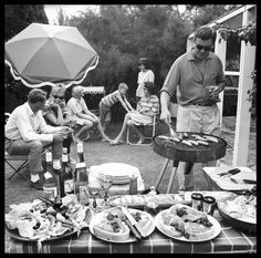 a group of people sitting around a table with food on it