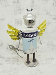 a toothbrush holder made to look like a robot with wings and measuring tape around it