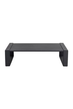 a black coffee table sitting on top of a white wall