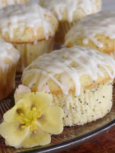 a muffin with icing and flowers on a plate