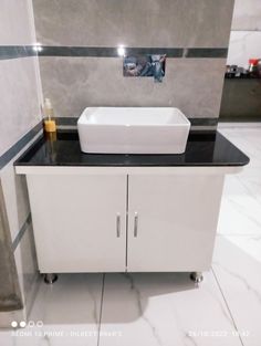 a white sink sitting on top of a black counter