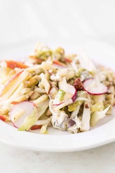 a white plate topped with pasta salad and radish sprouts on top of it