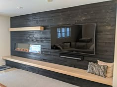 a flat screen tv mounted to the side of a wooden wall in a living room