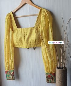 This Made to Order/Made to Measurement/Custom Made Indian Ethnic Blouse. - Fabric - Mul Cotton with Gold Mukaish Dots - Color - Yellow - Padded - Princess Cut - U Neck - Puffed Full Length Sleeves with Multicolor Border - Back Hook Closure - Border at the back Fabric Care : Dry Clean Only Disclaimer: The actual color of the product might slightly differ from the image due to photographic lighting or monitor's display Shipping: This is made to order product. Once you place the order we will provi Yellow Bohemian Blouse For Diwali, Bohemian Yellow Blouse For Diwali, Fitted Anarkali Blouse With Block Print, Fitted Traditional Wear With Block Print Long Sleeve, Bohemian Fitted Chanderi Lehenga, Fitted Long Sleeve Traditional Wear With Block Print, Yellow Long Sleeve Blouse Piece With Zari Work, Fitted Block Print Traditional Wear For Festivals, Fitted Traditional Wear With Block Print