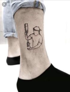 a person with a tattoo on their ankle holding a baseball bat and ball in one hand