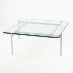 a glass table with metal legs on a white background