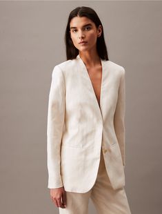 Made from a soft linen blend, this collarless blazer has a crisp, clean shape and a weightless feel. Styled with long sleeves and tailored with darts along the front. Created with hidden button closures, this blazer is a refined piece for an elevated wardrobe.  Material: 40% Cupro, 35% Linen, 25% Cotton. Classic Unstructured Linen Blazer, Tailored Linen Double-breasted Outerwear, Tailored Single-breasted Linen Outerwear, Linen Collared Single-breasted Outerwear, Single-breasted Linen Outerwear With Collar, Cotton Blazer, Linen Blend, Calvin Klein, Organic Cotton