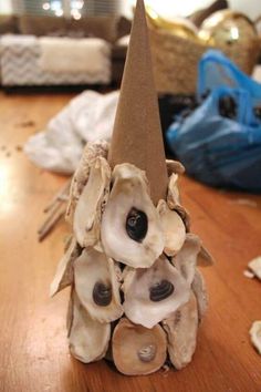 a cone shaped vase with seashells in it sitting on a wooden table next to other items