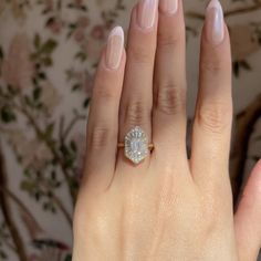 a woman's hand with a diamond ring on it