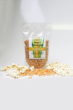 a bag of popcorn sitting on top of a white table next to some kernels