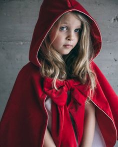 The Little Red Riding Hood cape is a luxury costume for children, handmade, in cotton velvet and satin lining. A fine gold border around the edge of the cape and the hood highlights the deep red of the velvet and the shine of the satin. The decorative bow is sewn on a button placket. The cape closes with a gold button. The sides of the knot measure approximately 30 cm (12"). The Little Red Riding Hood cape is shown in our photo with the Ballerinatulle dress for girls, but it can also be worn wit Red Riding Hood Cape, Tutu En Tulle, Hood Cape, Red Riding Hood Art, Red Ridding Hood, Red Riding Hood Costume, Girls Costumes, Season Decor, Handmade Costumes