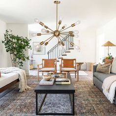 a living room filled with furniture and a large chandelier hanging from the ceiling