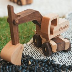 a wooden toy truck sitting on top of a pile of black beans