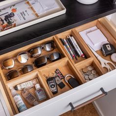 an organized drawer with sunglasses and other items