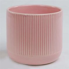 a pink vase sitting on top of a white table