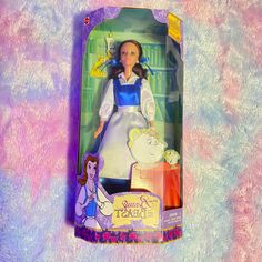 the doll is in its box and has an image of beauty and the beast on it