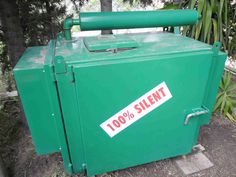 a green box with a sticker on it that says 100 % silent in front of some trees