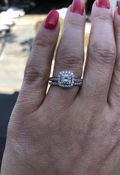 a close up of a person's hand with a diamond ring on their finger