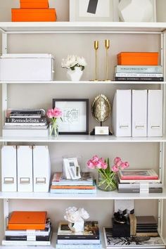 a bookshelf filled with lots of books and flowers