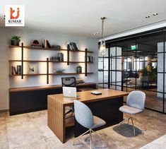 an office with two chairs and a desk in front of a glass wall that has bookshelves on it