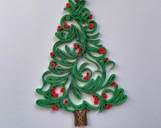 a paper christmas tree with red berries and green leaves on the top, hanging from a hook