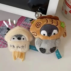 two stuffed animals sitting next to each other near a computer keyboard and mouse pad on a desk