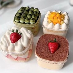 four desserts are arranged on a white table