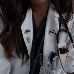 a woman wearing a white lab coat and holding a stethoscope in her right hand