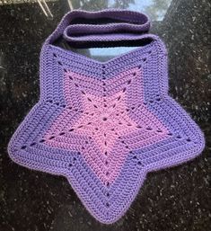 a purple crocheted bag sitting on top of a table