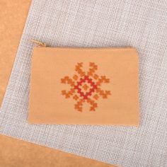 Perfect for carrying your personal items and makeup tools neatly, Ayda Santourian's newest creation combines the tender essence of cotton textiles with the magnificence of Armenia's Marash embroidery. Using a palette of beige and orange hues, the artisan crafts this cosmetic bag with a zipper closure, adding a flower-inspired cross-stitch embroidery accent at the front for a graceful vibe. Marash Embroidery, Cotton Textiles, Cotton Handbag, Orange Hues, Gift Suggestions, Cotton Textile, Premium Gift, Stitch Embroidery, Free Gift Wrapping