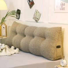 a bed with a pillow and stuffed animals on it in a room that has white walls