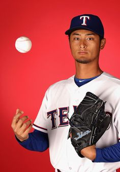 a man in a baseball uniform is throwing a ball into the air with his hands