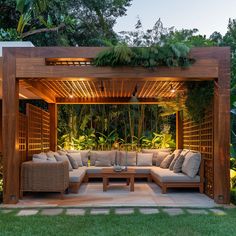 an outdoor living area with couches, tables and plants on the side of it