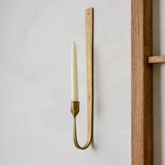 a candle is hanging on the wall next to a door handle and a wooden frame