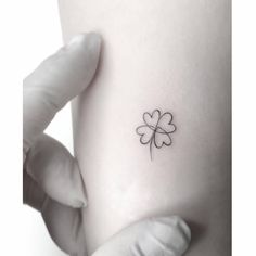 a small four leaf clover tattoo on the left side of the right arm and wrist