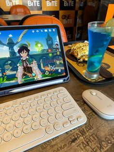 a tablet computer sitting on top of a wooden table next to a keyboard and mouse