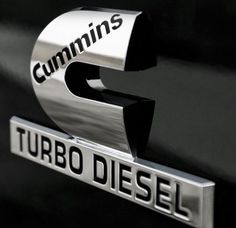 the emblem on a black car that says cummins turbo diesel in chrome letters