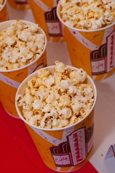 four buckets of popcorn sitting on a table