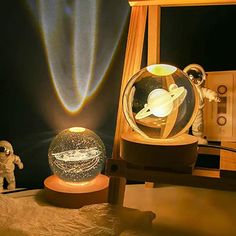 an astronaut is looking at the solar system in a glass ball on a wooden stand