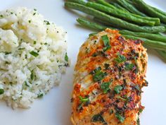 a white plate topped with rice and green beans next to meat covered in seasoning