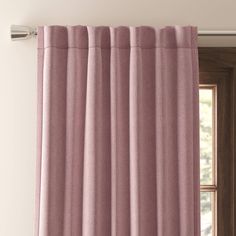 a pink curtain hanging on the side of a window