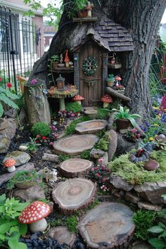 a fairy garden with lots of trees and mushrooms in the woods, including a tree stump house