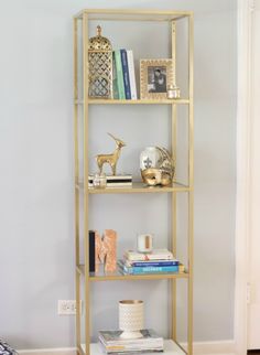 a book shelf with books and other items on top of it in a living room