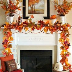 a fireplace decorated with fall leaves and pumpkins