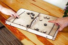 two people are playing an interactive game on a wooden table with flowers in the background