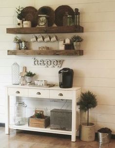 a white table topped with two shelves filled with coffee cups and other items on top of it